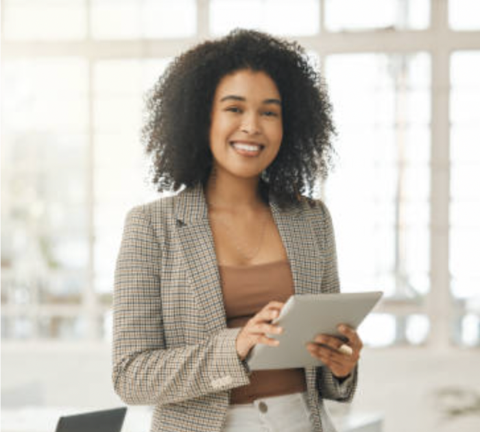 Smiling woman dressed in business casual holding a tablet