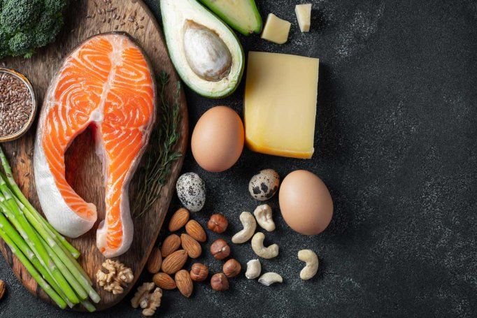Foods for ketogenic diets, which include high-fat foods like salmon, avocado, eggs, nuts, broccoli, asparagus, and cheese.