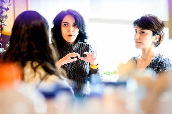 Three women in a deep and serious conversation at table.