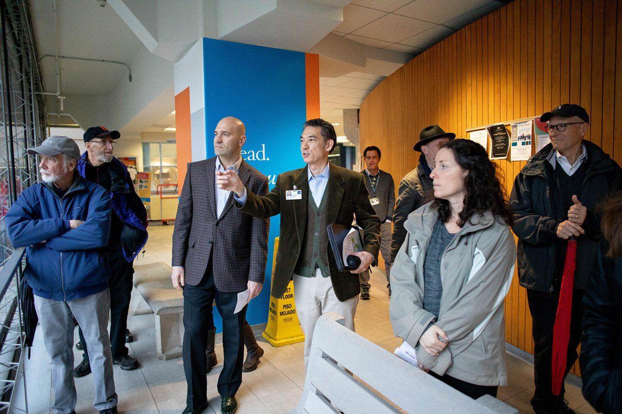 Community members stop to look out of a window during a tour of the Parnassus campus