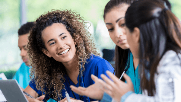 Woman leaning over to talk with classmates. 