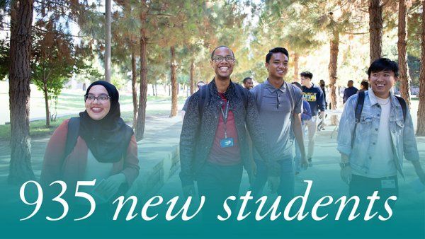 935 new students. A group of new students walk across the Mission Bay quad.