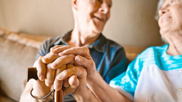 elderly couple holding hands