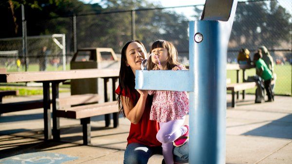 girl drinks from a water fountain