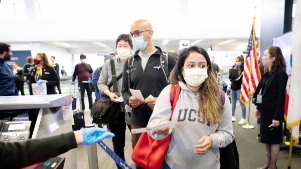 doctors line up to board a plane at San Francisco International Airport