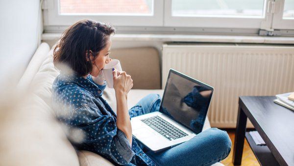 woman sitting on a couch using a laptop