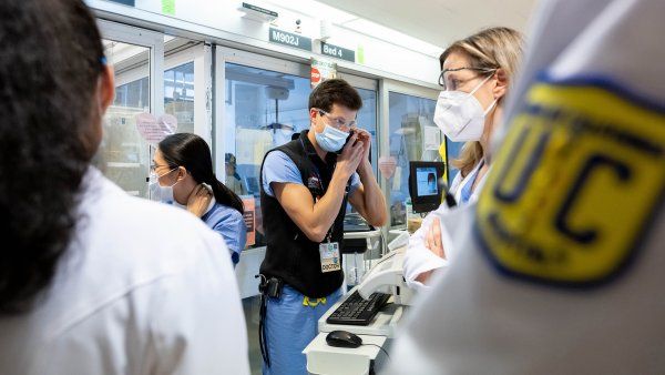 Medical workers crowd a Parnassus ICU as they treat COVID-positive patients