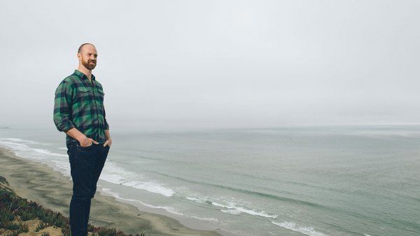 Matthew Wetschler, MD, stands on a sandy cliff overlooking the ocean.