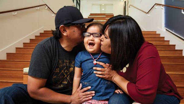 Photo of Joy Littlesunday hamming it up with her parents, Jarvison and Christina.