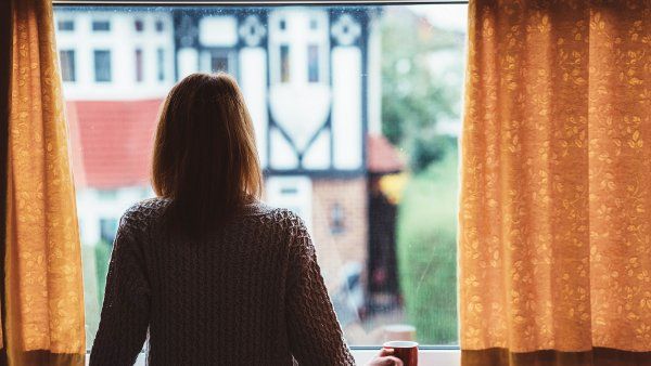 silhouette of a woman standing at a window