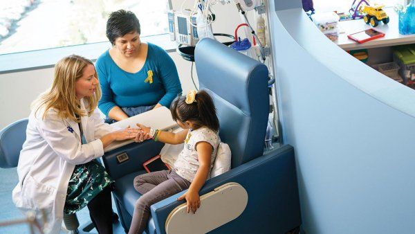 Janel Boyle treats a young patient while her mother looks on.