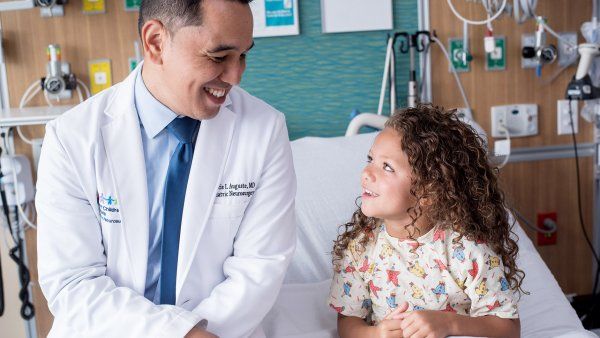 doctor smiles at young female patient 