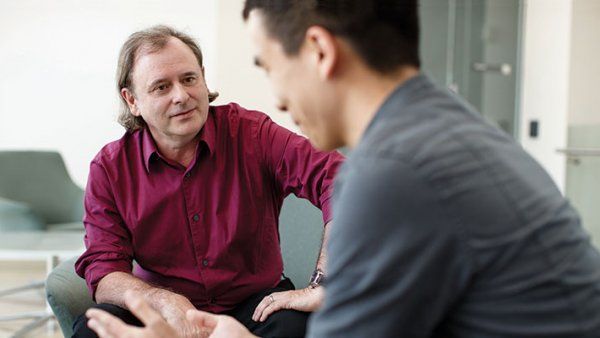 Photo of Alan Ashworth in conversation with a man.