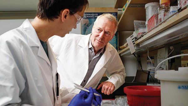 Allan Balmain talks to a research assistant in his lab.