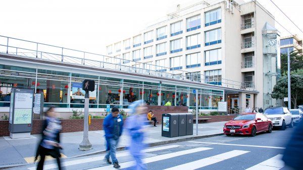 people walk across a crosswalk at UCSF Parnassus Heights campus