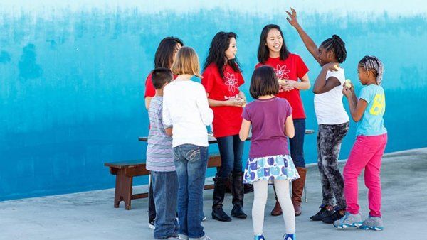 Members of the School of Pharmacy’s Science Squad (in red) deliver a lesson on circuitry to kids at Rosa Parks Elementary School.