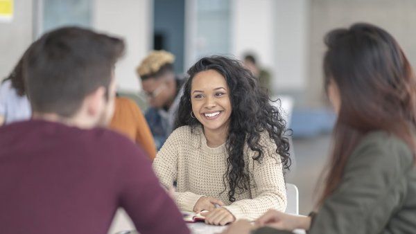 three students talk to one another