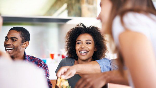 woman laughs with other two young people