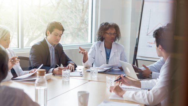 A group of multi-ethnic doctors in a boardroom having a meeting. 