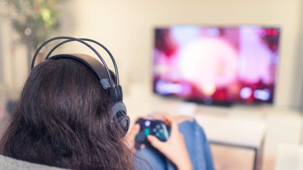 teenage girl playing video games in living room