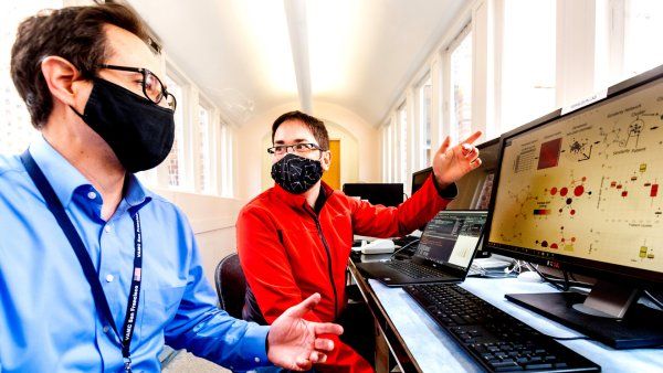 Abel Torres Espin, PhD, right, and Adam Ferguson, PhD, examine patient outcome data, visualized using machine learning on a computer