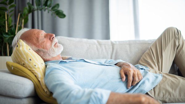 Elderly man taking a nap on a couch