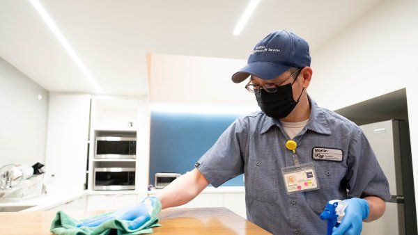 custodian cleans a tabletop