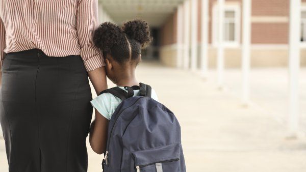 Black girl holds a woman's arm tightly