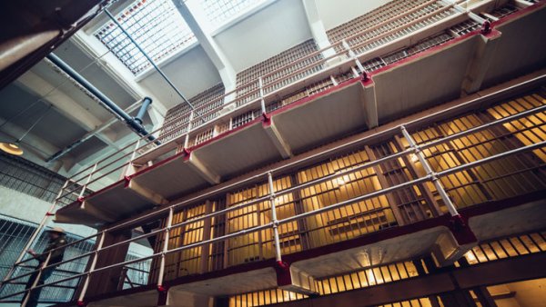 The interior of a prison. There are three floors of prison cells