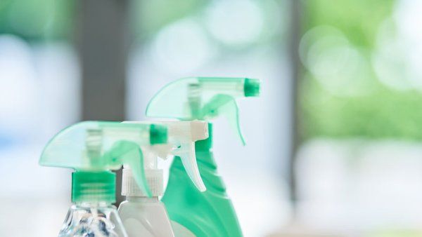 Three bottles of cleaning detergent. A window is in the background