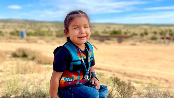 HT sits on the ground in Arizona and smiles