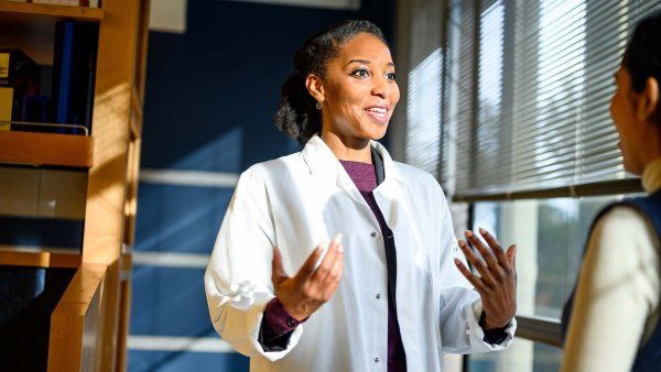 Catera Wilder talking with someone in her lab