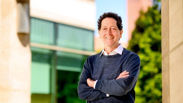 UCSF chemist Kevan Shokat stands for a portrait at Mission Bay. In the background is a building and a tree