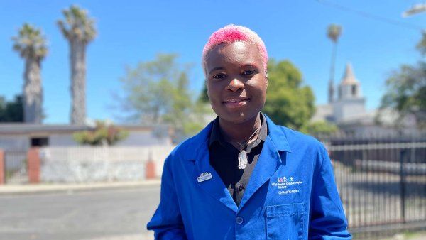 Ronelle McZeal poses in his blue coat on a street of Oakland.