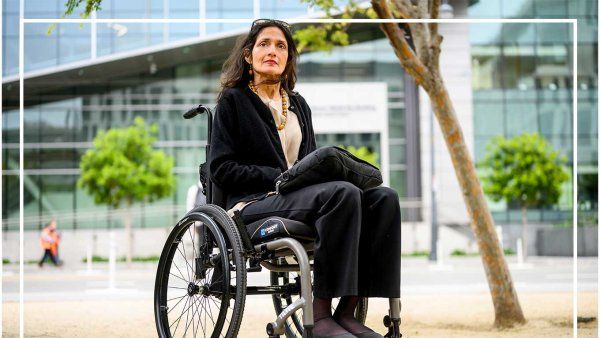 Janhavi Bonville sits in her wheelchair outdoors on a dirt path.