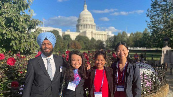 students smile in front of White House on a sunny day