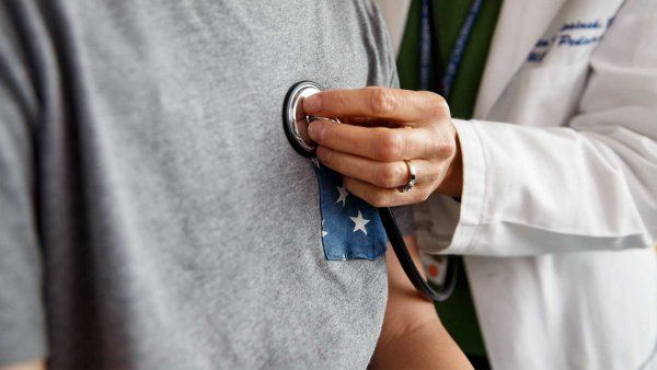 A doctor examines a patient with a stethoscope.