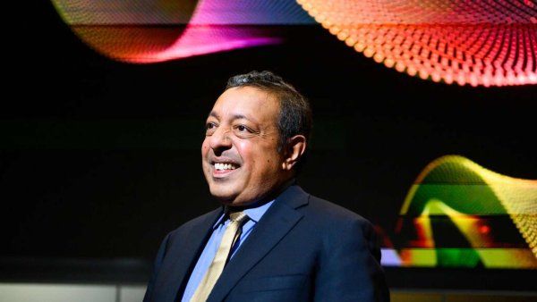 Atul Butte speaks in front of large colorful screen