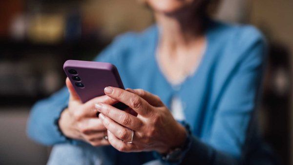 A middle-aged woman uses a smartphone.