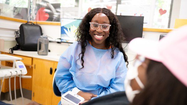 Paola Benefo and a staff member talk in the dental clinic.