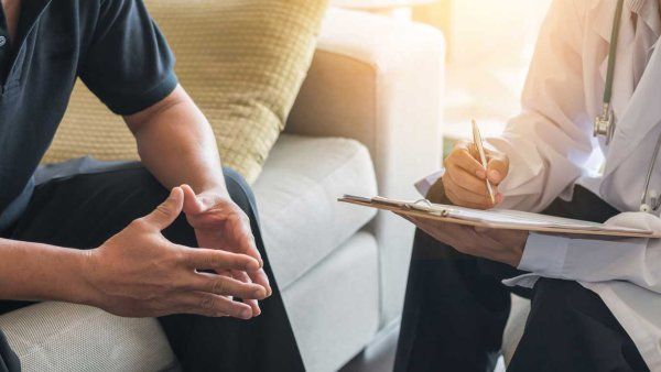 A male patient sits as he discusses with his doctor.