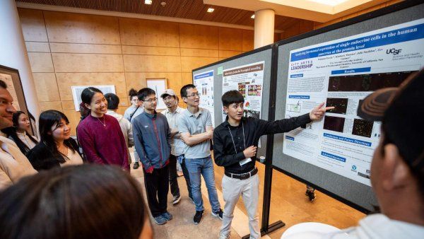 student points at poster to a crowd