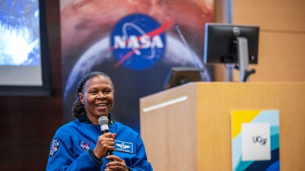 NASA astronaut Yvonne Cagle speaks at UCSF. In the background are banners featuring the NASA and UCSF logos.