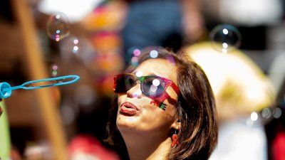 A woman in sunglasses blows bubbles