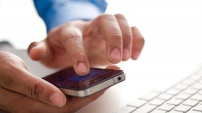 hands-using-smartphone-beside-computer.jpg