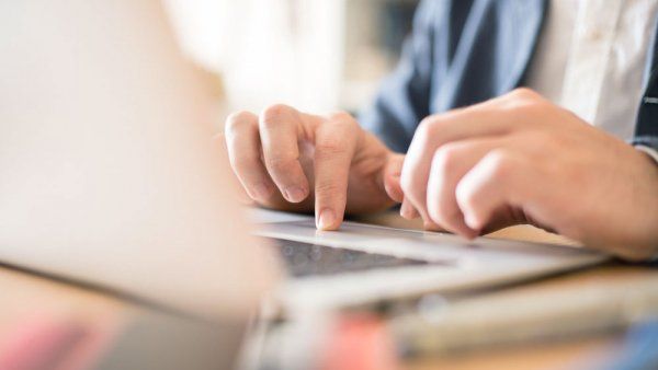 Hands typing on the laptop keyboard